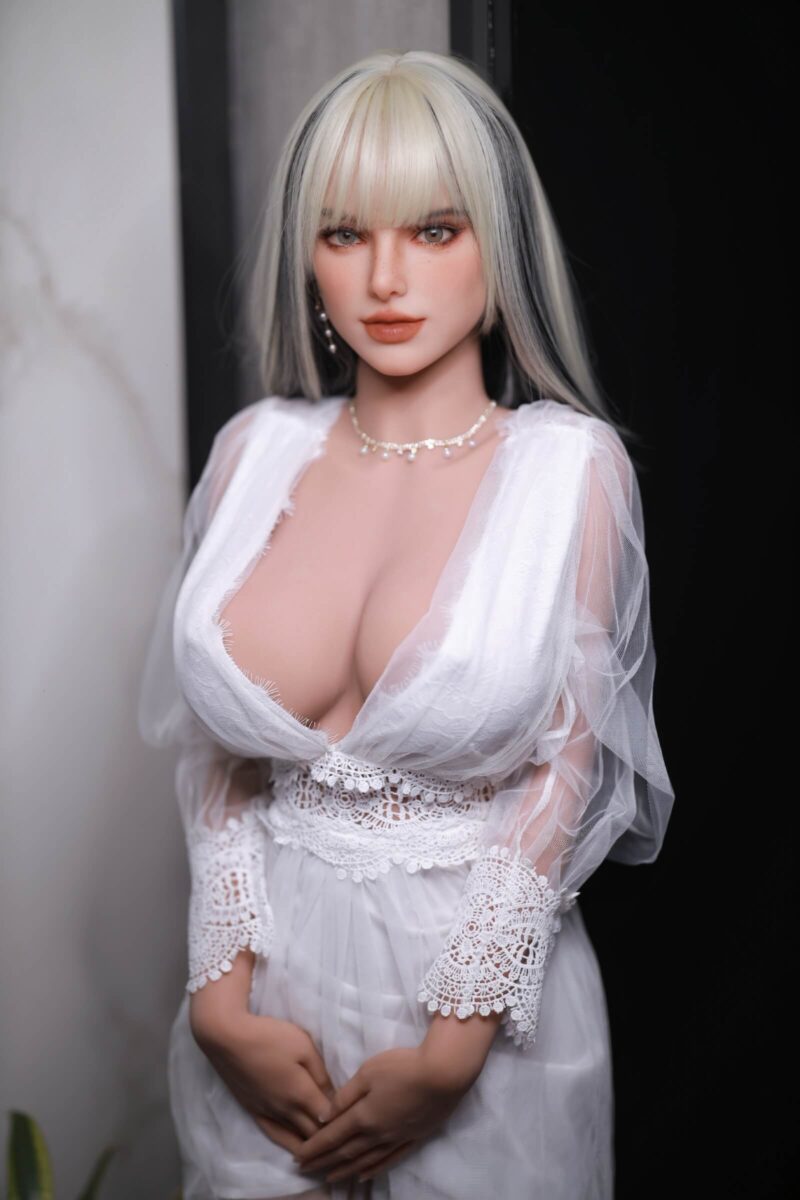 Poupée d'amour Tiana Blonde voluptueuse et plantureuse au regard angélique. En robe blanche.