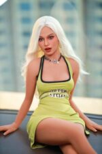 Poupée sexuelle blonde aux yeux bleus, assise sur une table